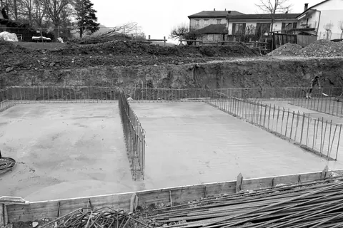 Platea di fondazione in cemento armato appena gettata, con i ferri di ripresa per le elevazioni